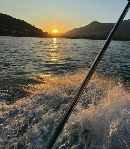 Sunset view from a boat on Lake Como with water reflections